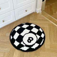 a black and white rug with a eight - ball on it in the middle of a wooden floor