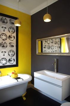 a white bath tub sitting next to a sink under a mirror in a bathroom with yellow walls