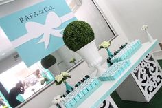 a table topped with vases filled with flowers next to a sign that says raae & co