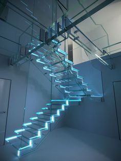 a glass staircase with blue lights going up it's side and down to the floor