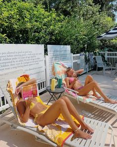 two women in bathing suits lounging on lounge chairs