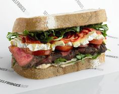 a large sandwich with meat, tomatoes and lettuce