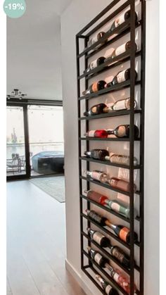 a wine rack with many bottles in it on the side of a wall next to a door