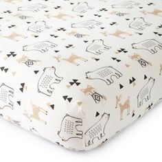 a baby crib sheet with black and gold animals on it, all over white