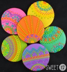 six brightly colored buttons with designs on them