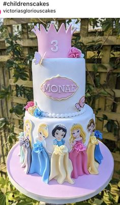 a three tiered cake with princesses on it