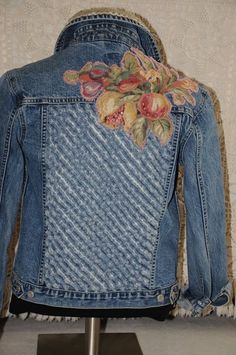 a denim jacket with floral appliques on the back