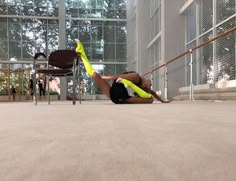 a woman doing a handstand on the ground in front of an office building