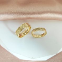 two gold rings with finger prints on them