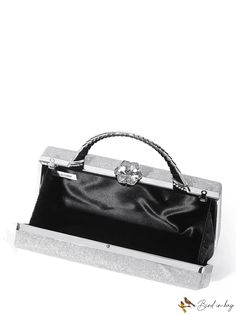 a black and silver handbag sitting on top of a white table