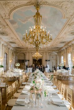 a long table set up with white linens and place settings for an elegant wedding