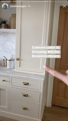 a kitchen with white cabinets and marble counter tops in the background is an advertisement for cabinet color is creamy white belphan moore