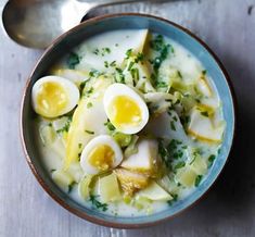 a bowl of soup with boiled eggs and parsley