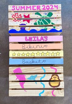 a wooden sign that says summer and has five different designs on the front, two are painted with acrylic paint