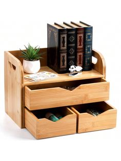 three books are stacked on top of each other in a wooden box with drawers underneath