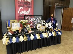 the table is set up for an event with decorations and letters on it, along with other items