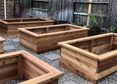 several wooden planters are lined up on the ground