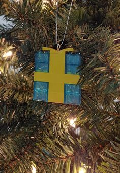 a yellow and blue ornament hanging from a christmas tree