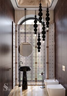 a bathroom with two sinks, mirrors and lights hanging from it's ceiling over the toilet