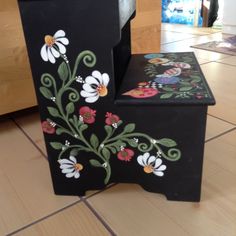 two black boxes with flowers painted on them sitting on the floor next to each other