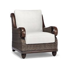 a brown wicker chair with white cushions