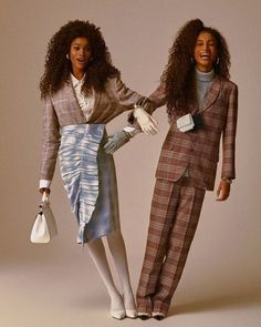 two women standing next to each other in front of a white background wearing plaid outfits