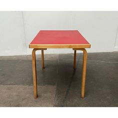 a red table sitting on top of a cement floor