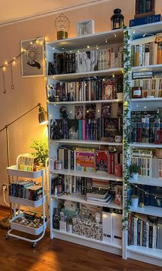 a bookshelf filled with lots of books next to a stair case in a living room