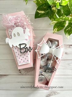 two pink boxes with white and black decorations