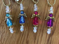 four different colored necklaces on a wooden table