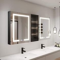 a bathroom with two sinks, mirrors and lights on the wall above them is shown