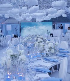 the tables are set with white flowers and blue napkins for an elegant wedding reception