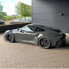 a grey sports car parked in front of a garage