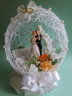 a wedding cake topper in the shape of a ball with a bride and groom on it