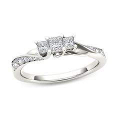 a three stone diamond ring on a white background