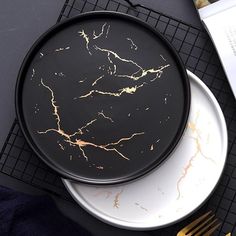 two black and gold plates sitting on top of a table