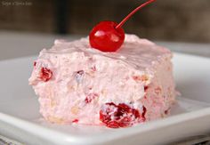 a close up of a piece of cake on a plate with a cherry on top