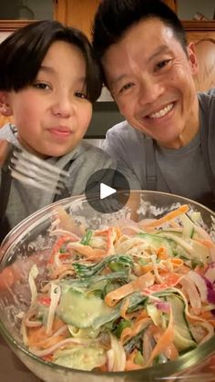 the man and child are posing for a photo in front of a bowl of food