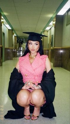 a woman sitting on the ground wearing a graduation cap and gown