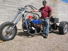 a man sitting on top of a motorcycle with a small engine in front of him