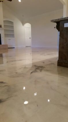 an empty living room with white walls and marble floors