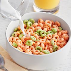 a white bowl filled with cereal next to a glass of orange juice