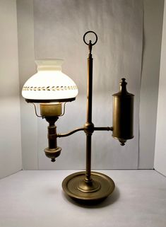 an old fashioned lamp with a white shade on it