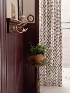 a potted plant sitting on top of a wooden table next to a shower curtain