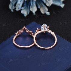 two rose gold wedding rings sitting on top of a blue napkin