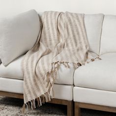 a white couch with a blanket on top of it