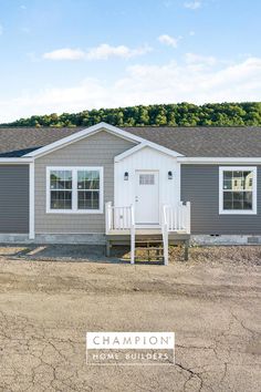 a gray and white mobile home with the words champion on it's front door