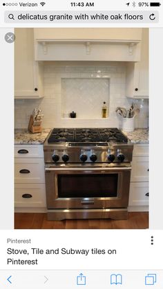 a stove top oven sitting inside of a kitchen next to white cabinets and counter tops