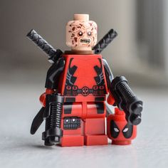 there is a lego deadpool character with two swords on his head and one eye open