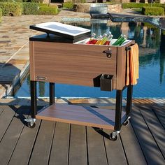 a cooler sitting on top of a wooden deck next to a pool